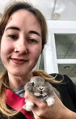 Patricia sujetando un conejo belier gris